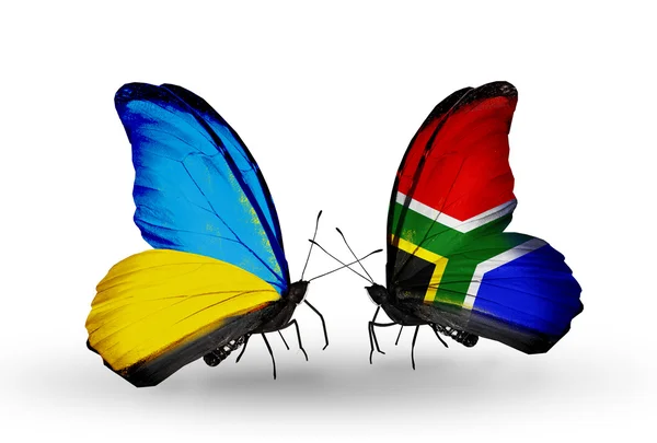 Due farfalle con bandiere sulle ali come simbolo delle relazioni Ucraina e Sudafrica — Foto Stock