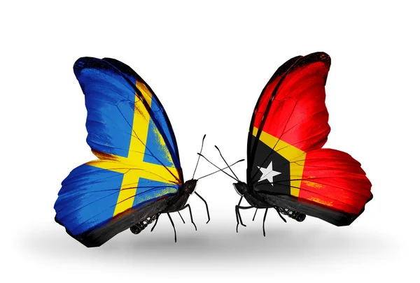 Dwa motyle z flagami na skrzydło symbol stosunki Szwecji i timor wschodni — Zdjęcie stockowe