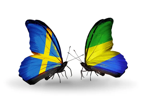 Zwei Schmetterlinge mit Flaggen auf Flügeln als Symbol der Beziehungen zwischen Schweden und Gabun — Stockfoto