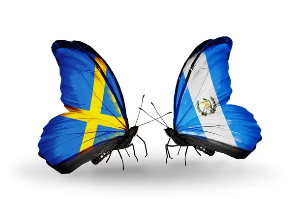 Deux papillons avec des drapeaux sur les ailes comme symbole des relations Suède et Guatemala — Photo