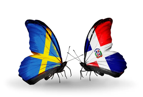 Zwei Schmetterlinge mit Flaggen auf Flügeln als Symbol der Beziehungen Schweden und Dominicana — Stockfoto