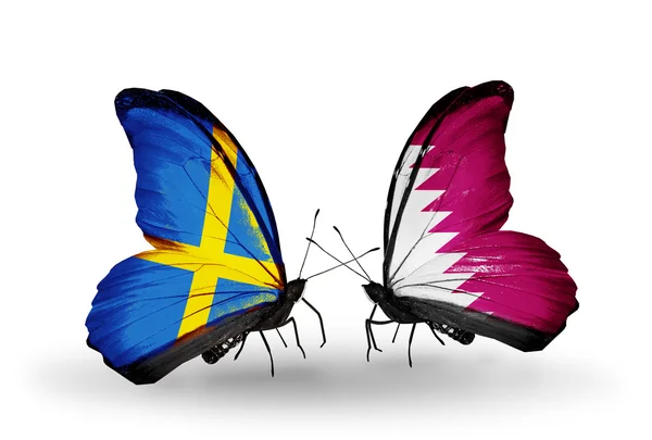Dwa motyle z flagami na skrzydłach jako symbol stosunki Szwecji i Katar — Zdjęcie stockowe