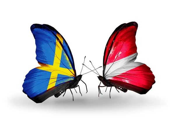 Dua kupu-kupu dengan bendera di sayap sebagai simbol hubungan Swedia dan Latvia — Stok Foto