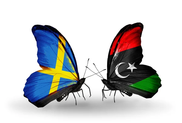 Две бабочки с флагами на крыльях как символ отношений Швеции и Ливии — стоковое фото