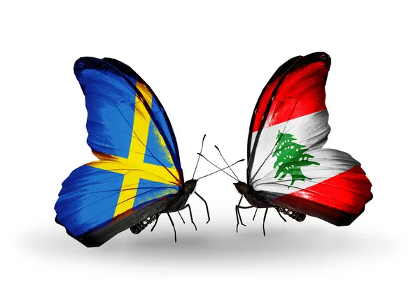 两只蝴蝶翅膀上的标志与符号的关系作为瑞典和黎巴嫩 — 图库照片