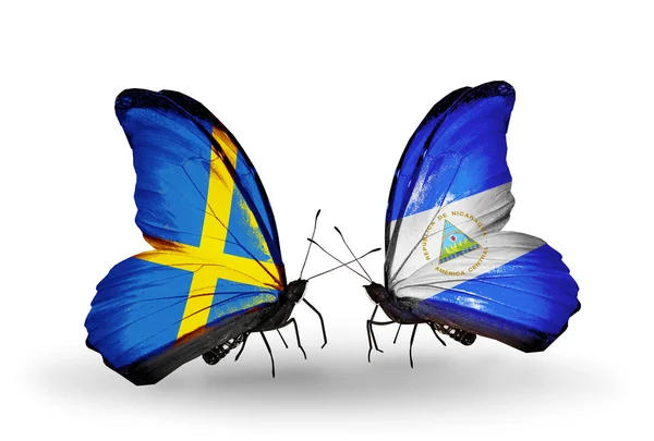 Две бабочки с флагами на крыльях как символ отношений Швеции и Никарагуа — стоковое фото