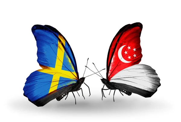 Duas borboletas com bandeiras em asas como símbolo de relações Suécia e Cingapura — Fotografia de Stock