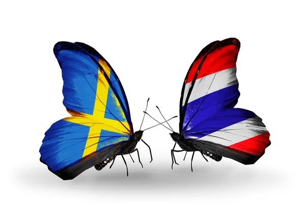 Zwei Schmetterlinge mit Flaggen auf Flügeln als Symbol der Beziehungen zwischen Schweden und Thailand — Stockfoto