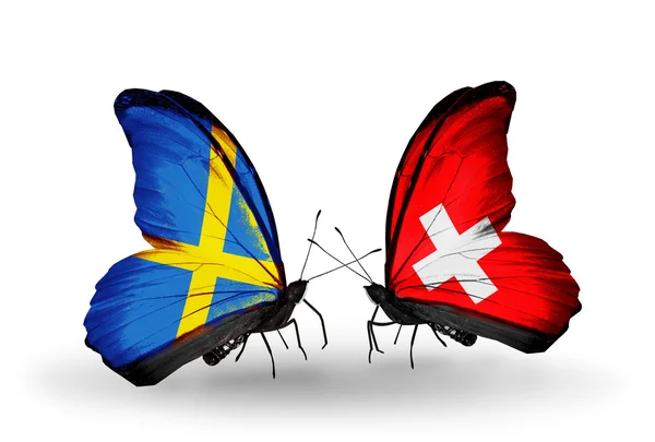 Two butterflies with flags on wings as symbol of relations Sweden and Switzerland — Stock Photo, Image