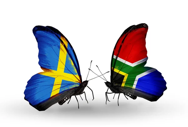Zwei Schmetterlinge mit Flaggen auf Flügeln als Symbol der Beziehungen zwischen Schweden und Südafrika — Stockfoto