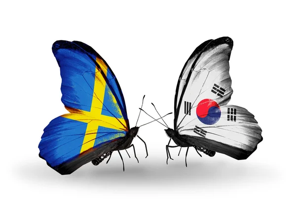 Twee vlinders met vlaggen op vleugels als symbool van betrekkingen Zweden en Zuid-korea — Stockfoto