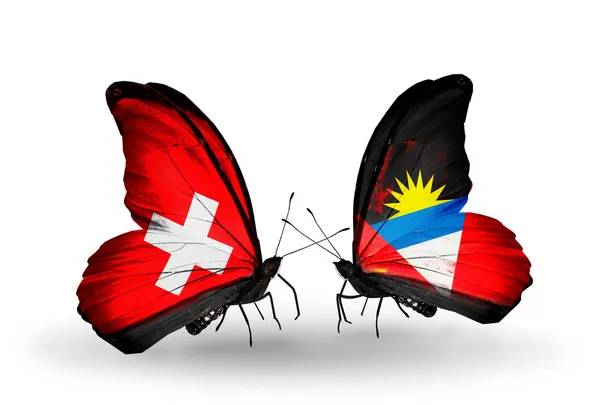 Two butterflies with flags of Switzerland and Antigua and Barbuda on wings — Stock Photo, Image