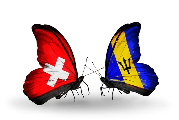 两只蝴蝶与瑞士和巴巴多斯的翅膀上的标志 — 图库照片