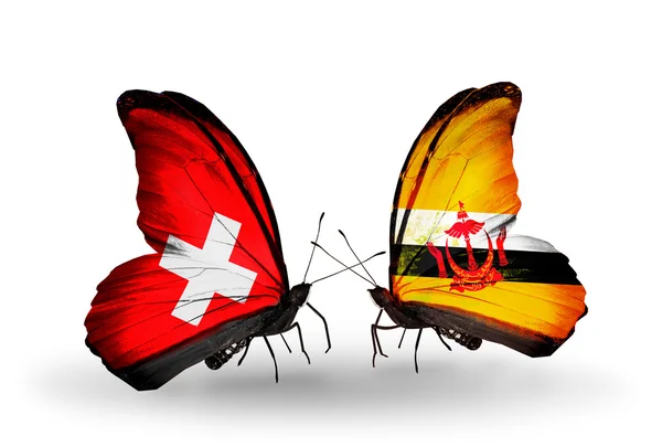Två fjärilar med flaggor i Schweiz och brunei på vingar — Stockfoto