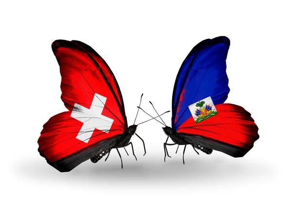 Two butterflies with flags of Switzerland and Haiti on wings — Stock Photo, Image