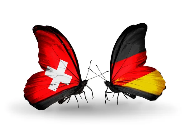 Due farfalle con le bandiere di Svizzera e Germania sulle ali — Foto Stock