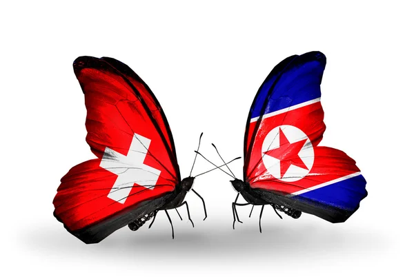 Two butterflies with flags of Switzerland and North Korea on wings — Stock Photo, Image