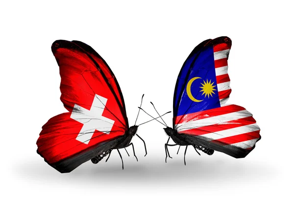 Δύο πεταλούδες με σημαίες της Ελβετίας και της Μαλαισίας σχετικά με φτερά — Φωτογραφία Αρχείου