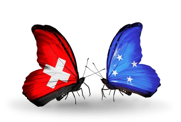 Dva motýli s vlajkami Švýcarska a Mikronésie na křídlech — Stock fotografie
