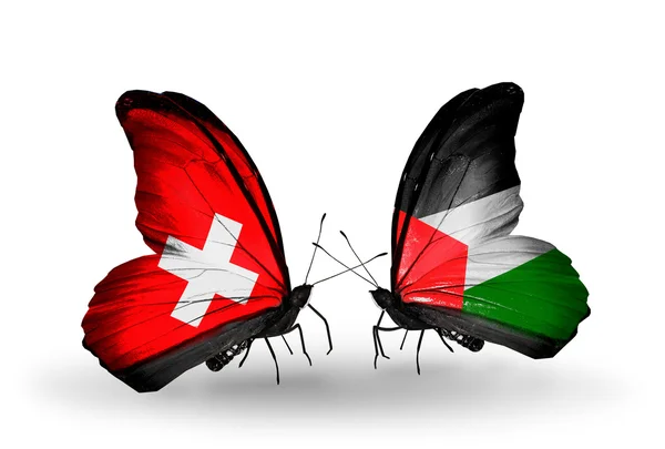 Dva motýli s vlajkami ze Švýcarska a Palestinou na křídlech — Stock fotografie
