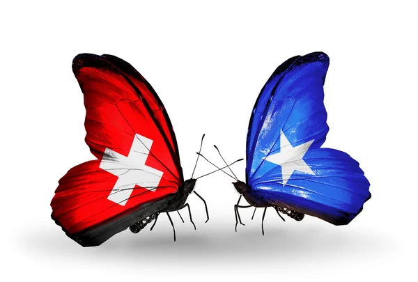 Deux papillons avec des drapeaux sur les ailes comme symbole des relations Suisse et Somalie — Photo