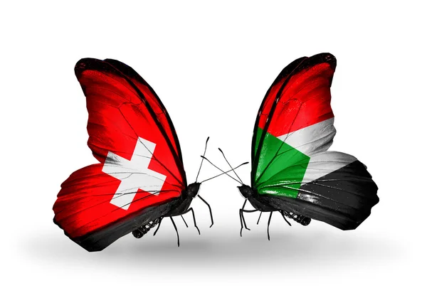 Dva motýli s příznaky na křídlech jako symbol vztahů, Švýcarsko a Súdán — Stock fotografie