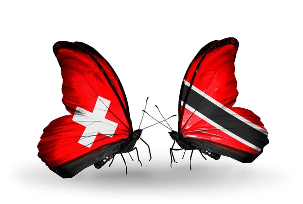 Twee vlinders met vlaggen op vleugels als symbool van de betrekkingen, Zwitserland en trinidad en tobago — Stockfoto