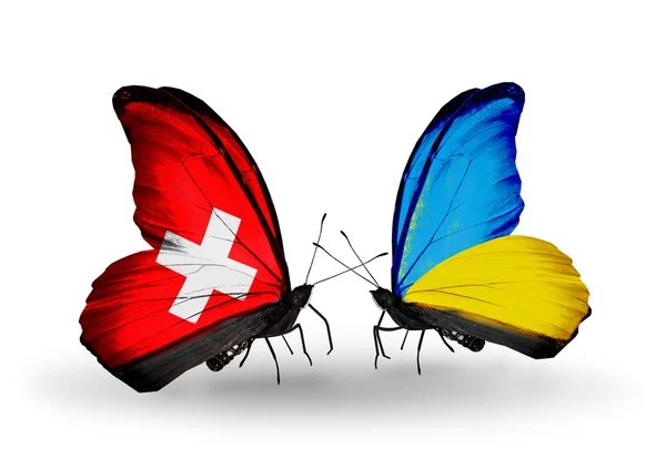 Two butterflies with flags on wings as symbol of relations Switzerland and Ukraine — Stock Photo, Image