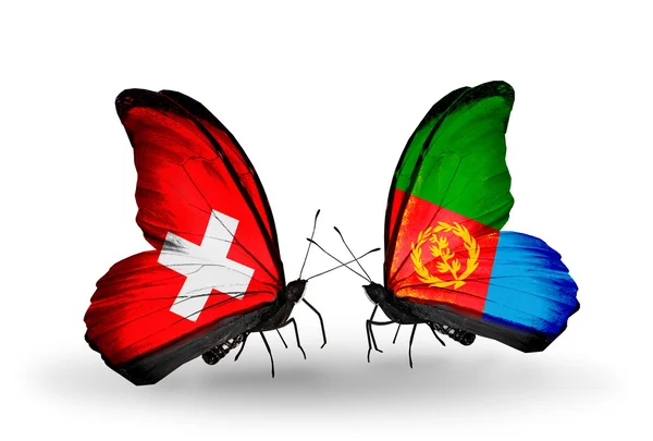 Dva motýli s příznaky na křídlech jako symbol vztahů, Švýcarsko a eritrea — Stock fotografie