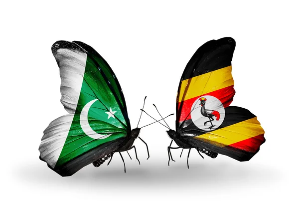 Dva motýli s vlajkami Pákistánu a Ugandy na křídlech — Stock fotografie