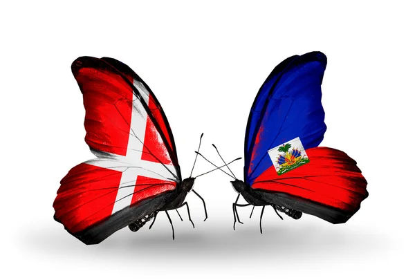 Dva motýli s vlajkami Dánska a haiti na křídlech — Stock fotografie