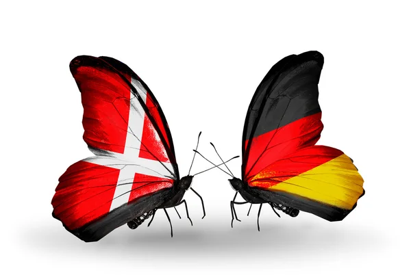 Dwa motyle z flag Niemiec i Danii na skrzydłach — Zdjęcie stockowe