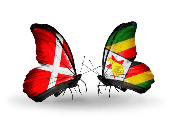 Dva motýli s vlajkami Dánska a zimbabwe na křídlech — Stock fotografie