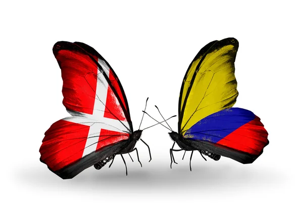 Dva motýli s vlajkami Dánska a columbia na křídlech — Stock fotografie