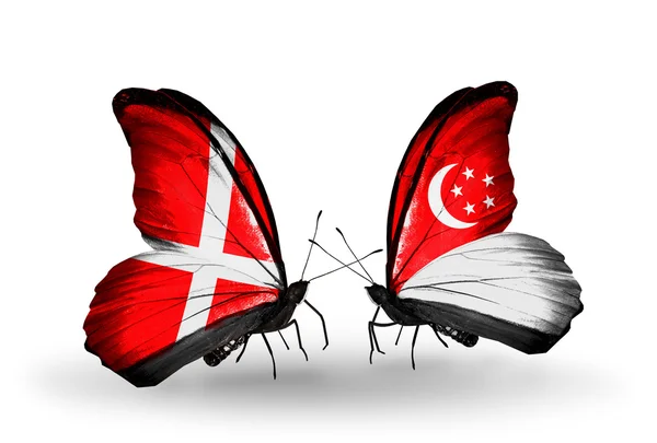 Duas borboletas com bandeiras da Dinamarca e Singapura em asas — Fotografia de Stock