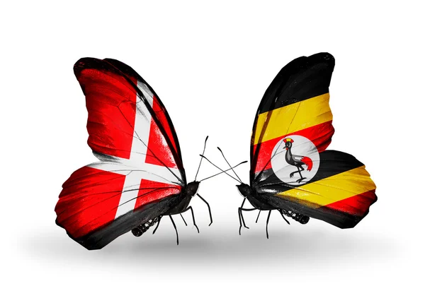 Twee vlinders met vlaggen van Denemarken en Oeganda op vleugels — Stockfoto