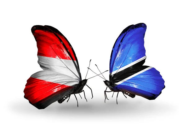 Zwei Schmetterlinge mit Fahnen von Österreich und Botswana auf Flügeln — Stockfoto