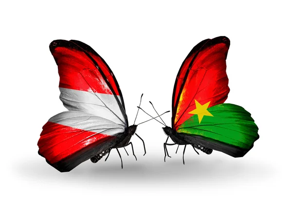 Две бабочки с флагами Австрии и Буркина-Фасо на крыльях — стоковое фото