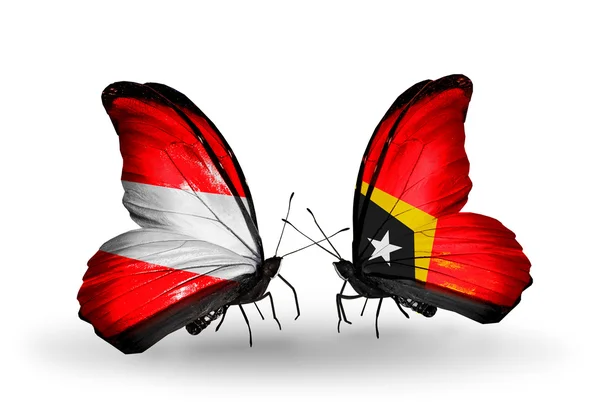 Två fjärilar med flaggor av Österrike och Östtimor på vingar — Stockfoto