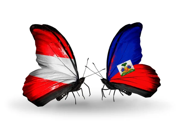 Dva motýli s vlajkou Rakouska a haiti na křídlech — Stock fotografie
