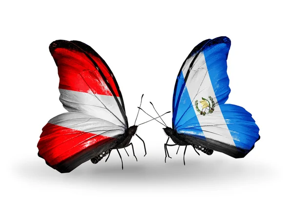 Dos mariposas con banderas de Austria y Guatemala en alas — Foto de Stock