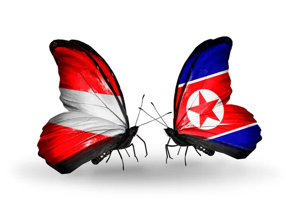 Dos mariposas con banderas de Austria y Corea del Norte en alas — Foto de Stock