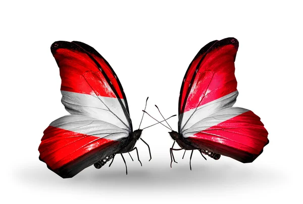 Dva motýli s vlajkami Rakouska a Lotyšsko na křídlech — Stock fotografie