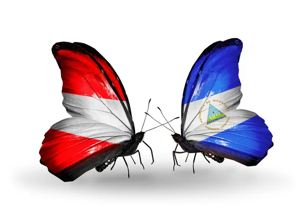 Duas borboletas com bandeiras da Áustria e Nicarágua em asas — Fotografia de Stock