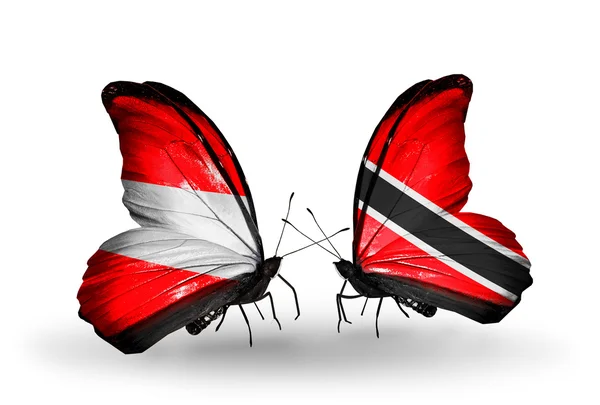 Zwei Schmetterlinge mit Fahnen von Österreich und Trinidad und Tobago auf Flügeln — Stockfoto