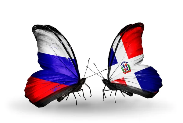 Dwa motyle z flagi Rosji i dominicana na skrzydłach — Zdjęcie stockowe