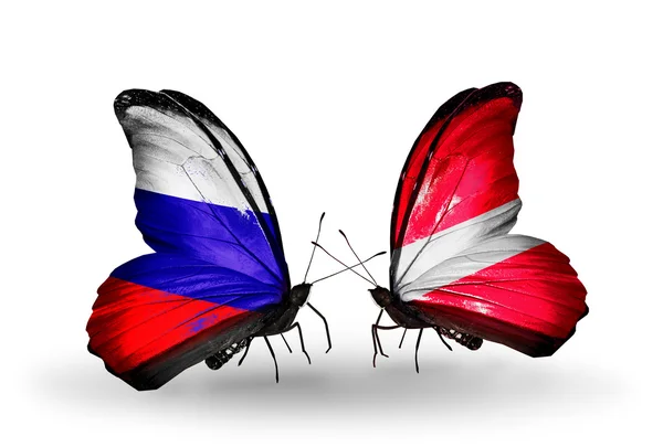 Deux papillons avec des drapeaux de la Russie et de la Lettonie sur les ailes — Photo