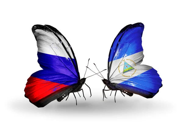 Dva motýli s vlajkami Ruska a Nikaraguou na křídlech — Stock fotografie