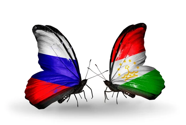 Dua kupu-kupu dengan bendera Rusia dan Tajikistan pada sayap — Stok Foto