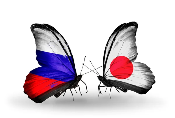 Dva motýli s vlajkami Ruska a Japonska na křídlech — Stock fotografie